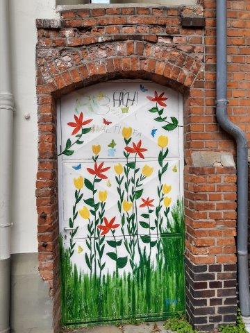 Graffito Blumenwiese an Häuserwnd